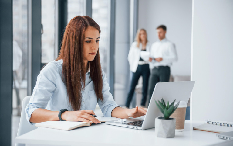 Woman with laptop sitting in front of group