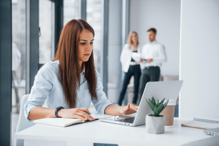 Woman with laptop sitting in front of group